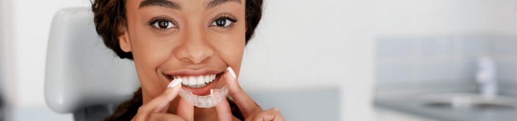 smiling black girl holding invisible aligner modern teeth trainer.jpg s1024x1024wisk20c idpwx4DFyAHLpLVjSwnew2EebFUEvLKOWkR7JJC7V4